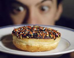 Don’t risk the temptation to tamper. Email signature security 1 A close up of a donut with chocolate icing and rainbow sprinkles on a plate, with a man's wide-eyed face in the background.