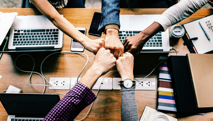 The Importance of Trust in SaaS Partnerships: 7 Reasons Partners Trust Rocketseed 8 Close up top view of business people putting their hands together, showing teamwork and unity