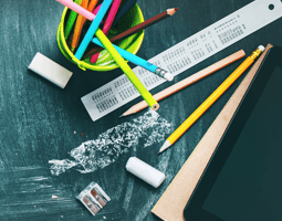 4 ways educational institutions can engage with email signature and banner campaigns 8 Pencils, a ruler, chalk and an eraser sit on a chalkboard background.
