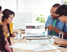 What is an HTML email signature, and how do I design one? 11 A man points to a laptop screen showing the Rocketseed email banner and signature; a man and two women look at it.