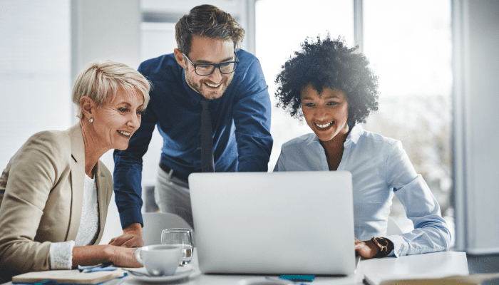 Why Big Businesses Need More Than an Email Signature Generator: Discover Enterprise Email Signature Solutions 4 A group of professionals looking at a laptop