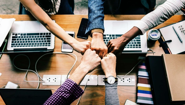 Why is Rocketseed 'Trusted by IT'? 12 Five arms reach over laptops to fist bump in the center of a table.