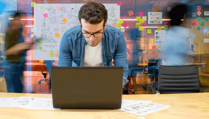 The Power of Direct Email Signature Marketing and Banner Integration 1 A man standing behind a laptop with a blurred office background