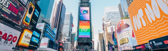 Time Square A buy time square with people walking in the street and and billboards are lighting the scene