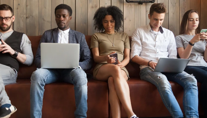 Managing the gender pronoun issue in email signatures: why centralized control is key 8 Five individuals sitting in a row on their laptops and cellphones in front of a wooden wall